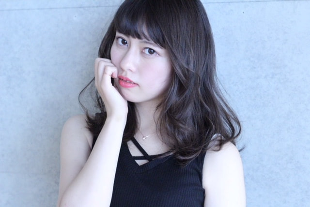 縦巻きカールの女性（右顎に手を置いてる））