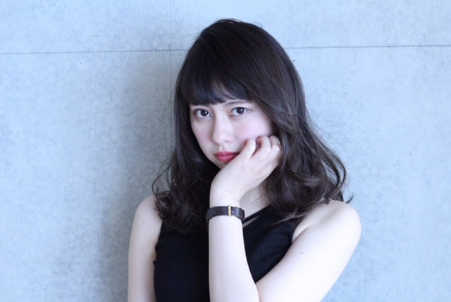 縦巻きカールの女性（右顎に手を置いてる）