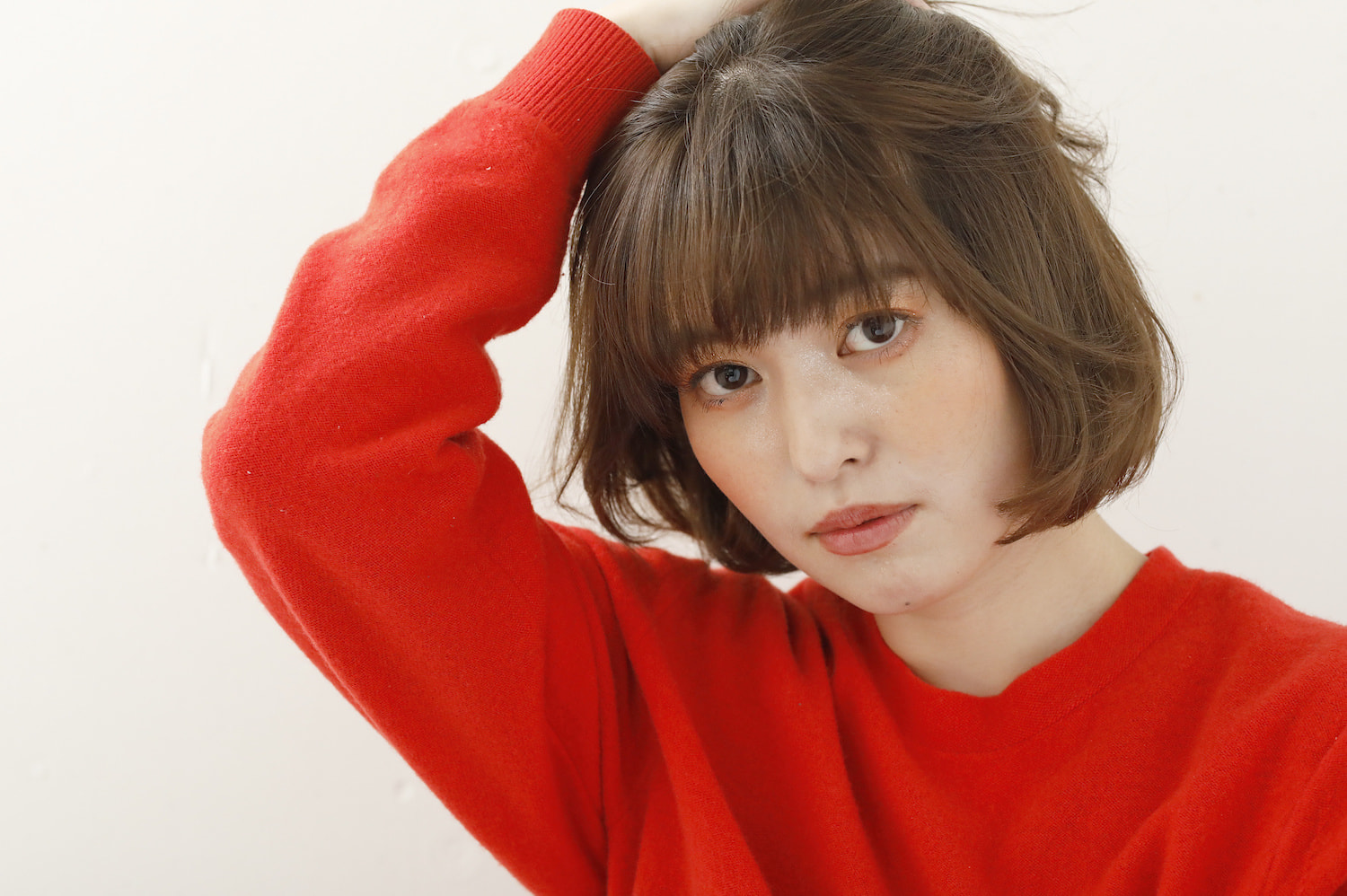 ふんわりミニボブの女性(頭に右手のせてる)