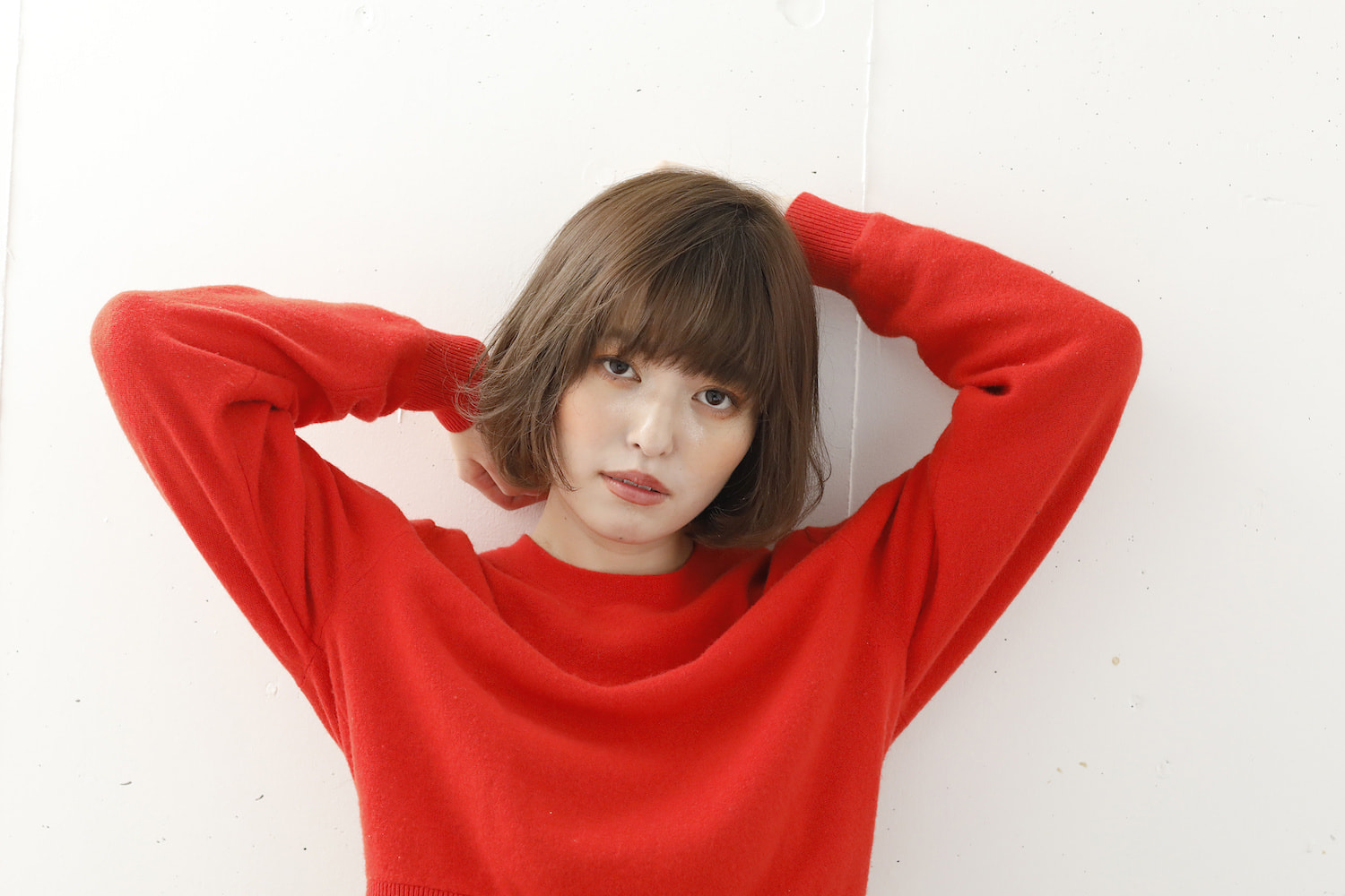 両手を上げたふんわりミニボブの女性