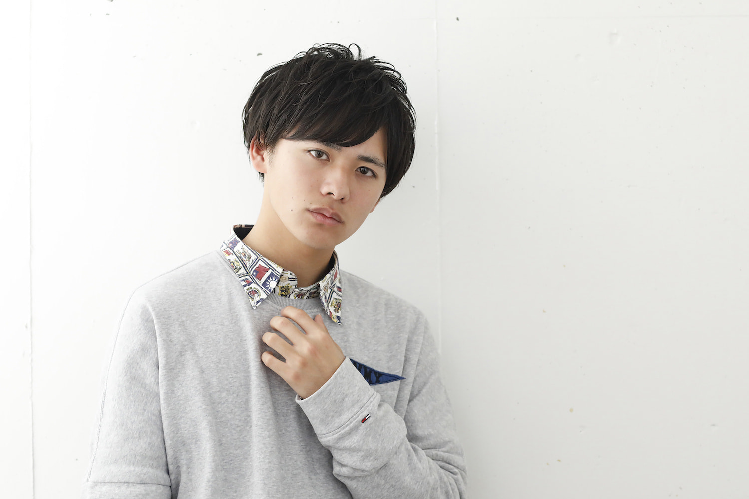 フラッフィーショートヘアの男性（腕に胸に当ててる）