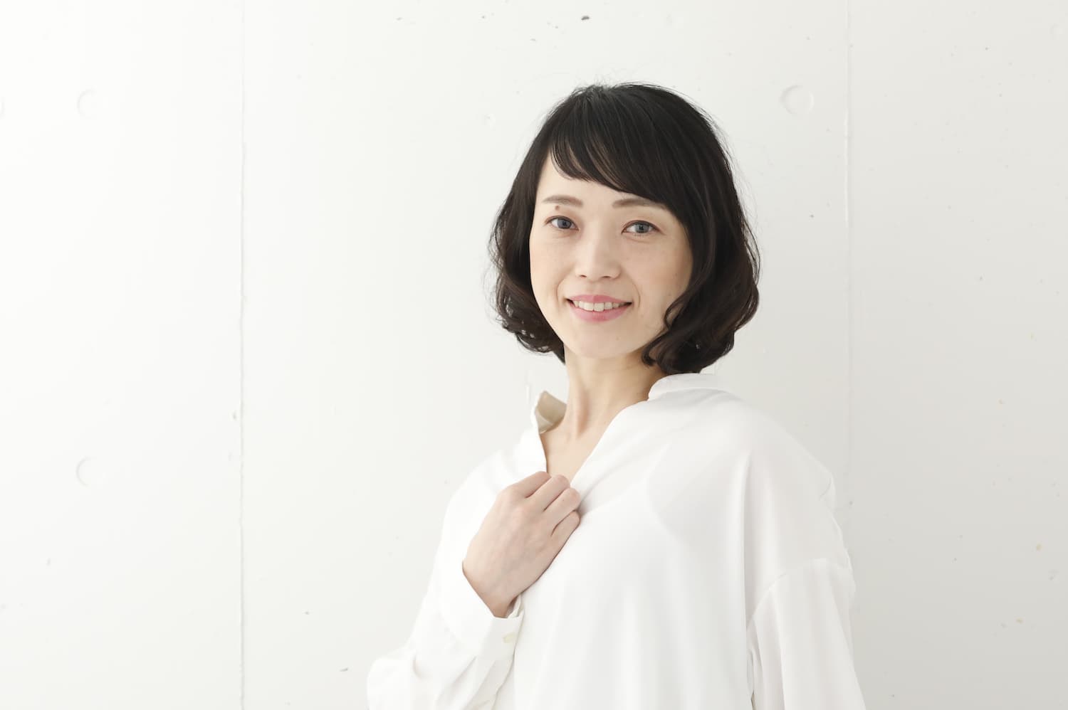 パーマのあるボブスタイルの女性（画面右寄り）